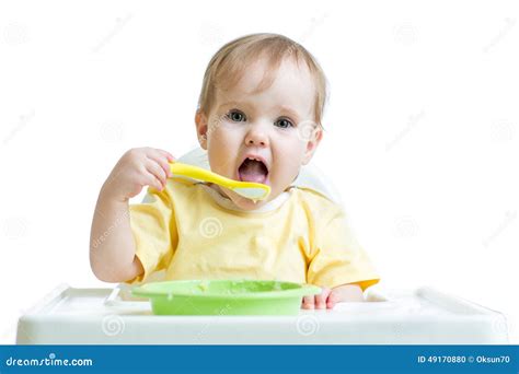 Bambino che osserva un cucchiaio con scetticismo