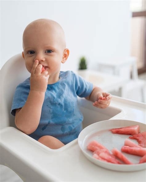 Bambino che gioca con il cibo sul seggiolone