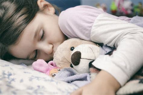 bambina che dorme con un peluche
