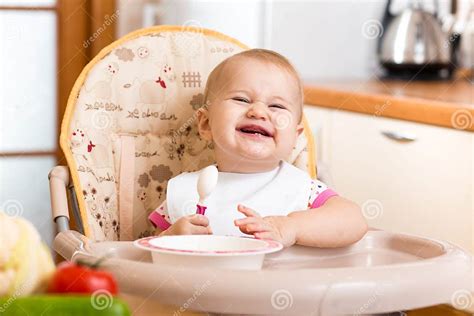 bambino che mangia su un seggiolone in legno