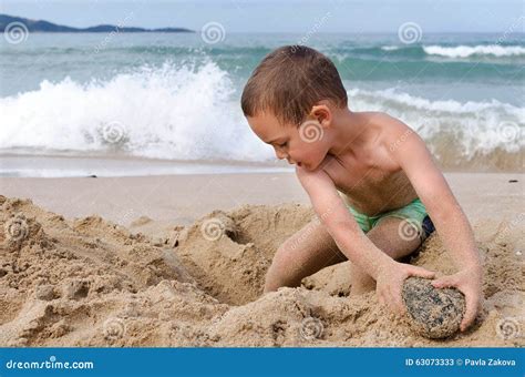 Bambino che gioca in spiaggia con la protezione solare