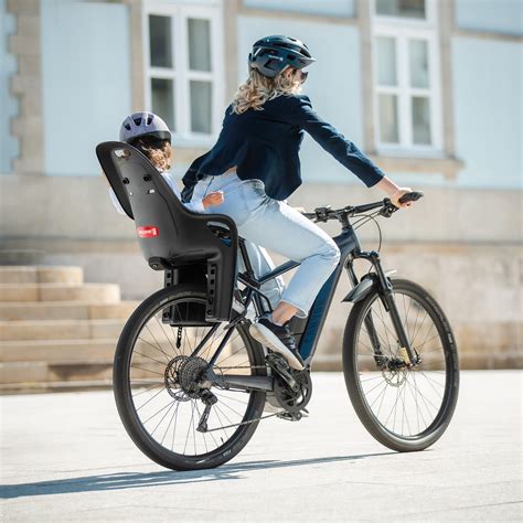 Coppia in bicicletta con bambino su seggiolino posteriore
