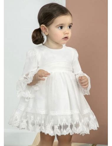 Bambina con vestito da battesimo bianco in pizzo