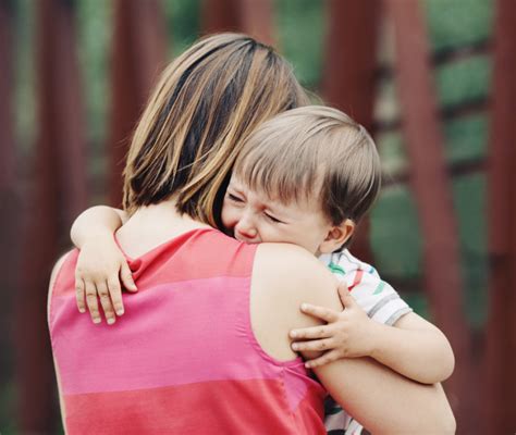 bambino che piange salutando un genitore all'ingresso di una scuola