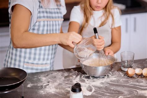 Bambina che mescola una cioccolata in una cucina giocattolo