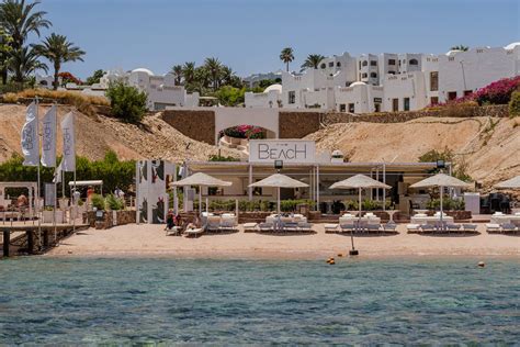 Una spiaggia tropicale con lettini e ombrelloni al Domina Coral Bay