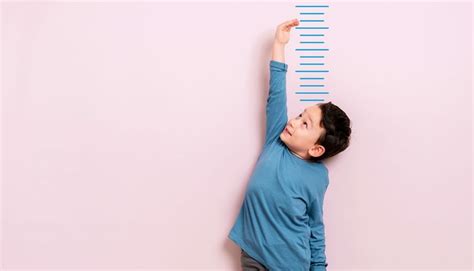Bambino in crescita che misura la sua altezza con un metro
