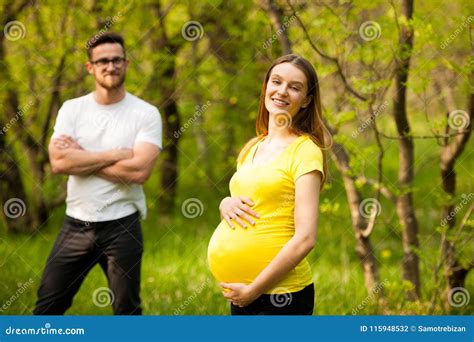 Donna incinta con il partner in un parco con luce soffusa