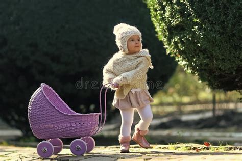 bambino che gioca con passeggino per bambole