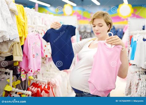 Donna incinta che sceglie vestiti