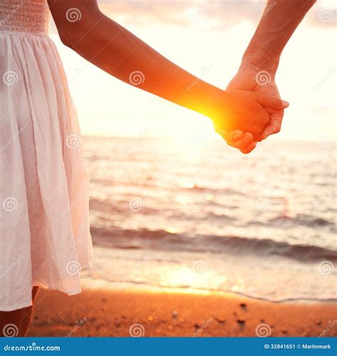 coppia che si tiene per mano in spiaggia
