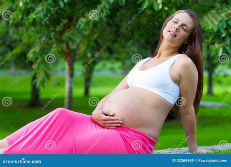 donna incinta che si protegge dal sole con un cappello