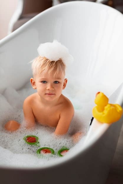 Bambino che gioca nella vasca con prodotti Mustela