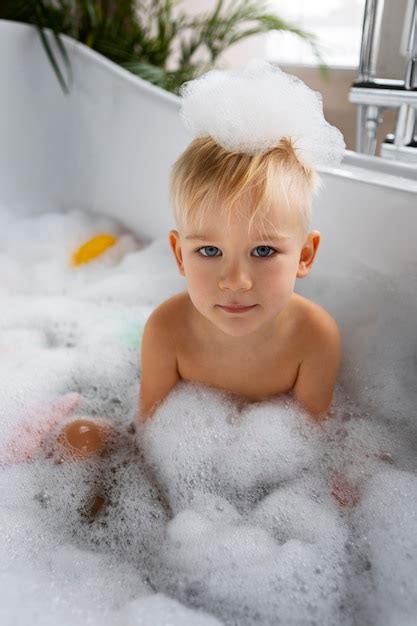 bambino che gioca con retino da pesca nella vasca da bagno