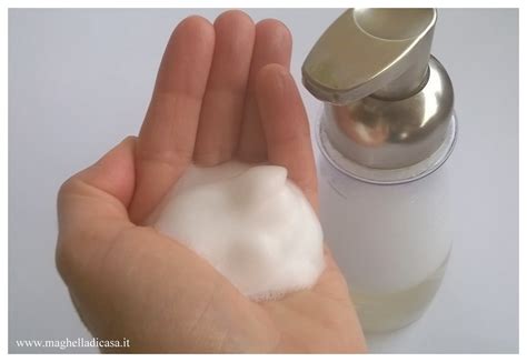 Mani che creano schiuma da un flacone di detergente