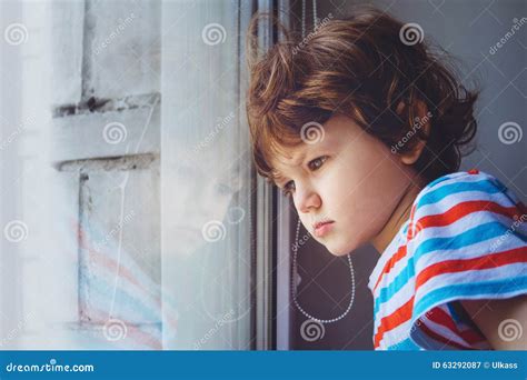 bambino che guarda dalla finestra di un negozio mentre un genitore spinge un passeggino leggero