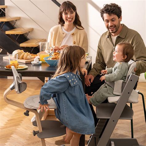 Famiglia che mangia a tavola con bambini sui seggioloni Tripp Trapp