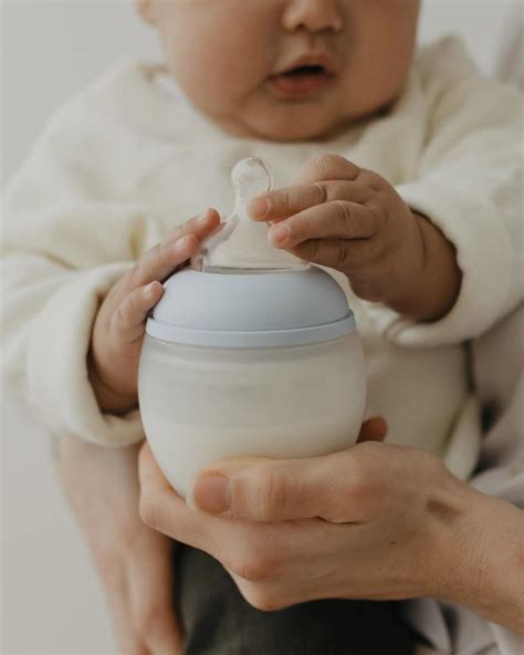 Neonato che beve latte materno dal seno della madre
