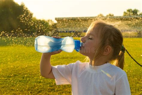 Bambino che beve acqua da una borraccia