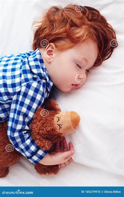 Bambino che dorme con un peluche