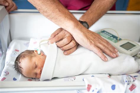 Neonatologo che esegue uno screening uditivo su un neonato