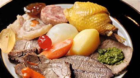 Un tavolo apparecchiato con un piatto di bollito misto e una ciotola di bagnet verd