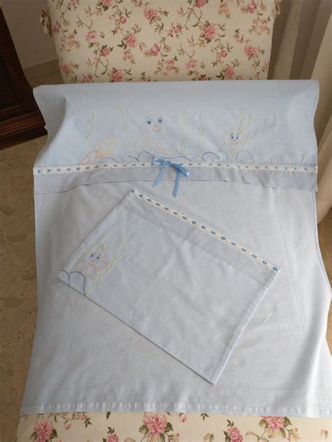 Primo piano di un dettaglio ricamato su un lenzuolino per neonato