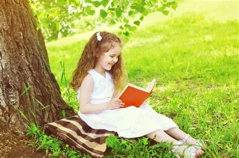 Bambina che legge un libro con un sorriso