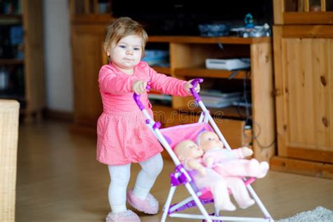 bambino che spinge un passeggino per bambole