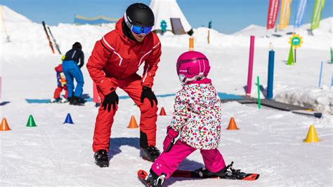 Bambini che imparano a sciare su una pista dolce con maestri di sci