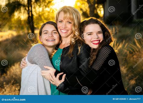 Due mamme che abbracciano le loro figlie